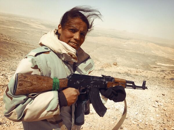 Женщина - доброволец штурмовой группы отряда ополчения Соколы пустыни продвигается по стратегическим высотам к Пальмире. Сирия,  24.03.2016