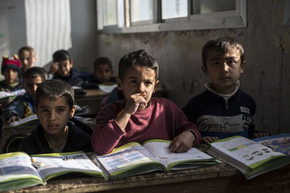 На уроке в школе поселения для беженцев в населенном пункте Аль-Ком провинции Кунейтра. Сирия, 15.12.2015