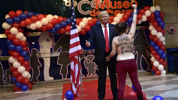 Активистка Femen с фигурой Дональда Трампа в Музее восковых фигур в Мадриде