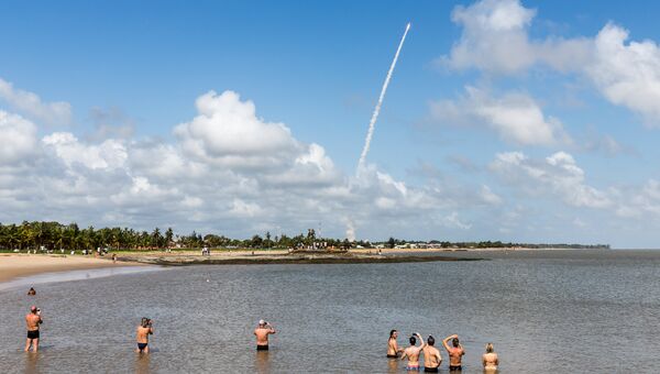 Люди наблюдают за пуском ракеты Ariane-5 со спутниками Galileo с косодрома Куру. 17 ноября 2016 года