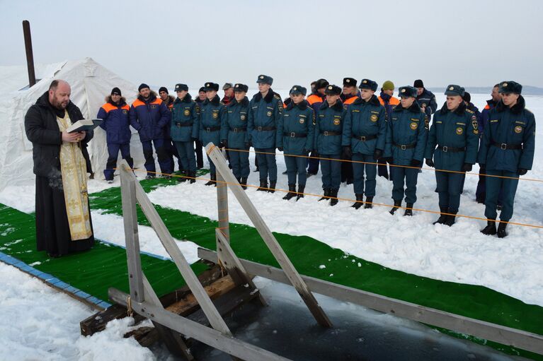 Священнослужитель освящает крещенскую купель, подготовленную сотрудниками МЧС РФ, на льду Амурского залива во Владивостоке