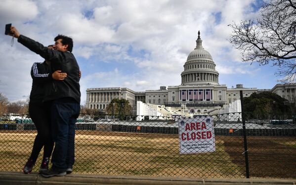 Люди фотографируются на фоне Капитолия в Вашингтоне