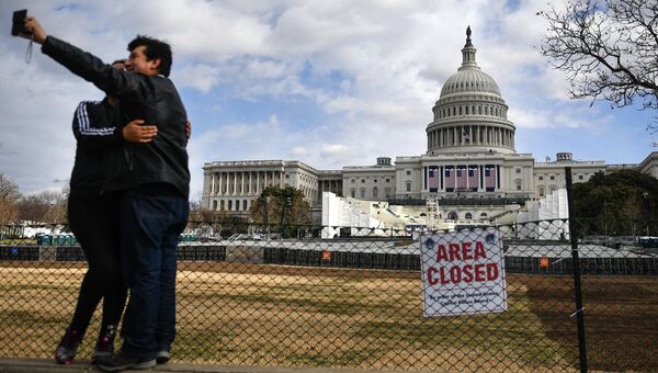 Люди фотографируются на фоне Капитолия в Вашингтоне