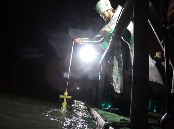 Священник проводит молебен и освящение воды перед крещенским купанием в источнике Красных пещер в Симферопольском районе Крыма