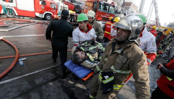 Пожарные на месте обрушения высотного здания Пласко в Тегеране