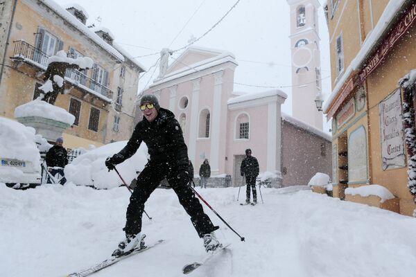 Мужчины катаются на лыжах по улице французского острова Корсика