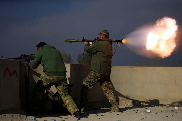 Бойцы иракских сил безопасности стреляют в сторону боевиков ИГ во время сражения на юге Мосула