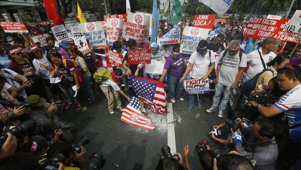 Протестующие сжигают флаг США у посольства США в Маниле, Филиппины. 20 января 2017