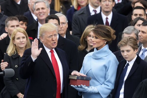Президент США Дональд Трамп (слева) приносит присягу на церемонии инаугурации в Вашингтоне