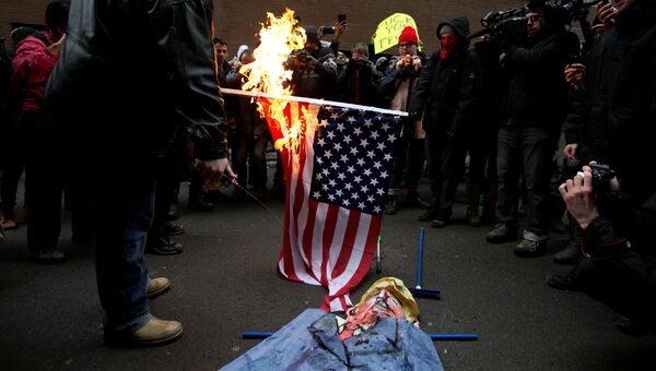 В Монреале протестующие против президентства Трампа сожгли флаг США. 20 января 2017 год