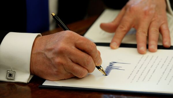 Президент США Дональд Трамп во время подписания документов. 24 января 2017 года