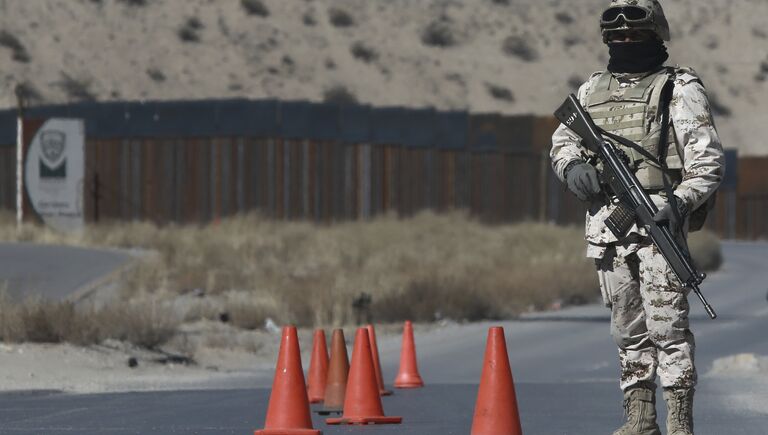 Мексиканский солдат на контрольно-пропускном пункте возле пограничного забора между Мексикой и США
