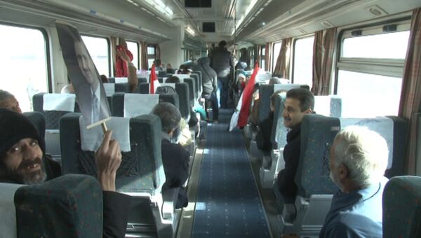 Сирийцы с портретами Асада ехали в первом с начала войны поезде через Алеппо