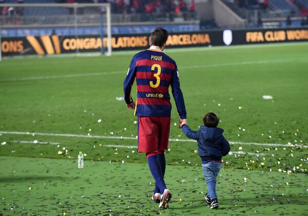 Футболист Жерар Пике с сыном на стадионе в Токио. 2015 год