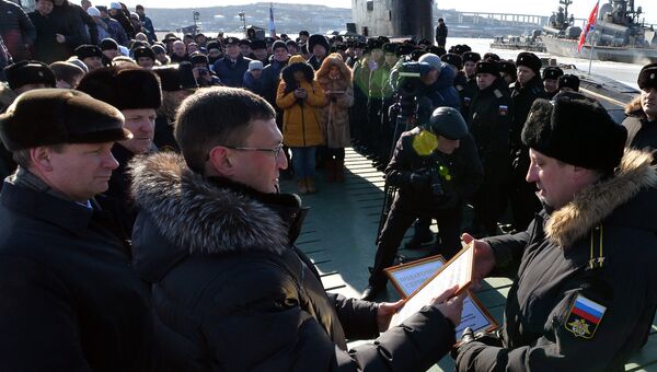 Мэр Комсомольска-на-Амуре Андрей Климов вручает командиру подводной лодки Комсомольск-на-Амуре проекта 877 Палтус капитану 2-го ранга Андрею Бодаку подарочные сертификаты