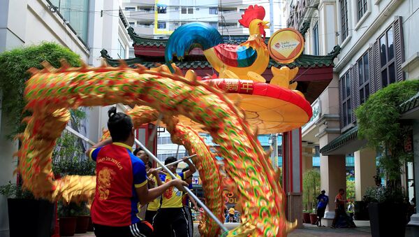 Студенты выполняют традиционный танец дракона в китайском квартале в преддверии Нового года в городе Бинондо, Манила
