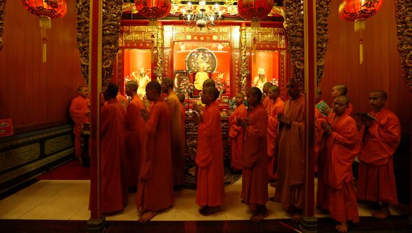 Буддийские монахи молятся в храме во время празднования китайского Нового года в Бангкоке, Таиланд. 27 января 2017