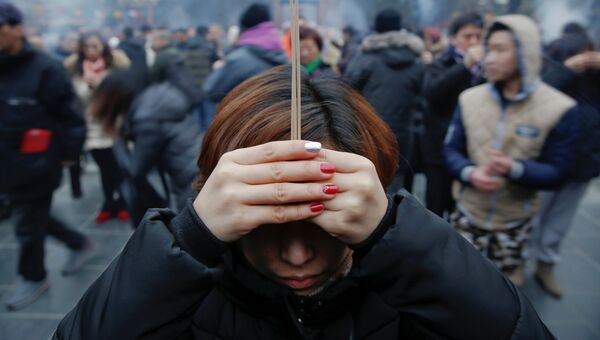 Люди молются в храме Юнхэгун Лама в первый день китайского Нового Года в Пекине, Китай. 28 января 2017 года