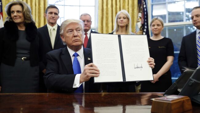 Президент США Дональд Трамп держит один из подписанных указов. Архивное фото