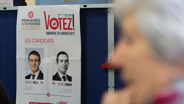 Портреты кандидатов в президенты от Социалистической партии Франции Мануэля Вальса и Бенуа Амона на избирательном участке в Париже. 29 января 2017 года