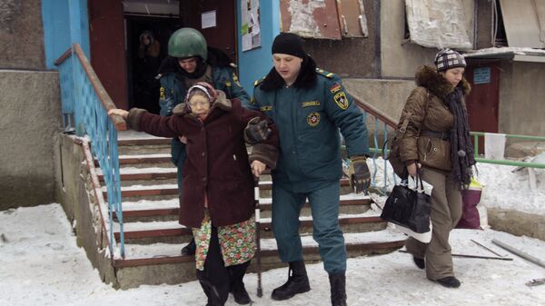 Сотрудники МЧС ДНР помогают жительнице спуститься во время эвакуации людей из опасных районов Донецка