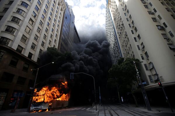 Автобус, подожженный антиправительственными демонстрантами во время акция протеста против правительства в Рио-де-Жанейро, Бразилия