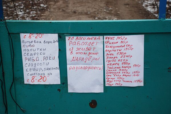 Объявления о продаже продуктов на воротах дома в селе Коминтерново Донецкой области