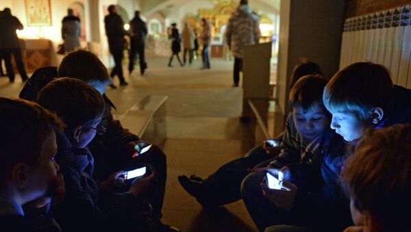 Дети играют в мобильные телефоны в Успенском соборе в Омске
