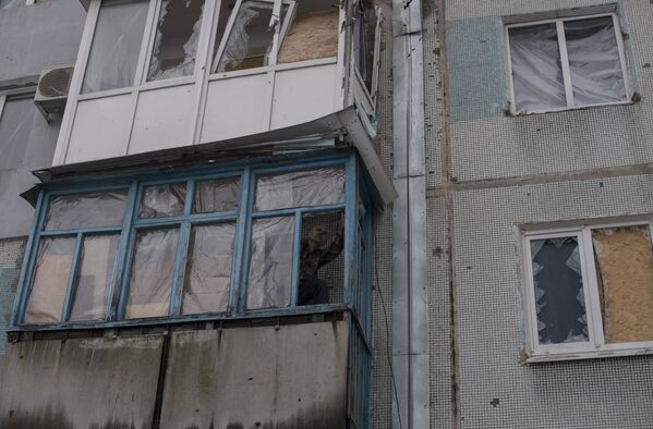 Мужчина заделывает балкон пленкой в Киевском районе Донецка
