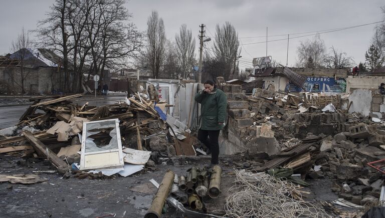 Женщина у разрушенного здания в районе автостанции Мотель в Донецке