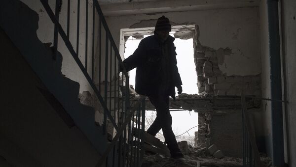 Местный житель в поврежденном в результате обстрелов здании в Киевском районе Донецка