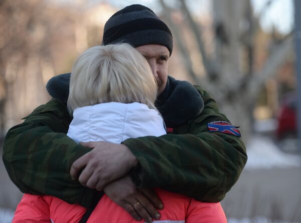 Женщина прощается с ополченцем ДНР перед отправкой автобусов с беженцами из Донецка в Россию