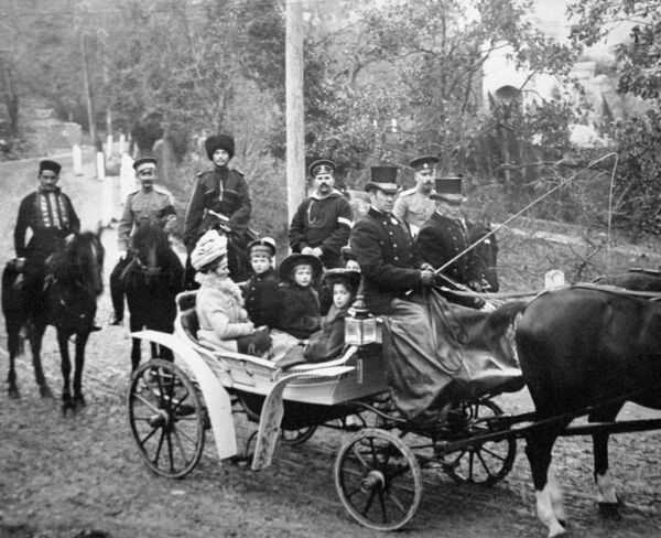 Царевич Алексей с сестрами сидит в коляске во время прогулки по Царскому селу
