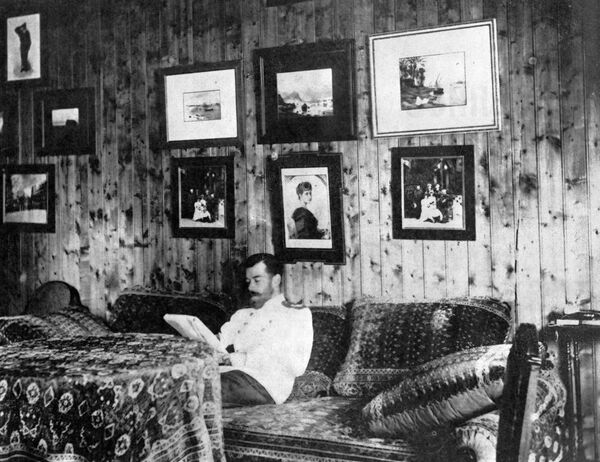 Император Николай II сидит на диване в своей комнате в охотничьем домике