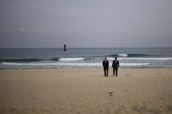 Мужчины в деловых костюмах на пляже Gyeongpo Beach в городе Каннын, Республика Корея