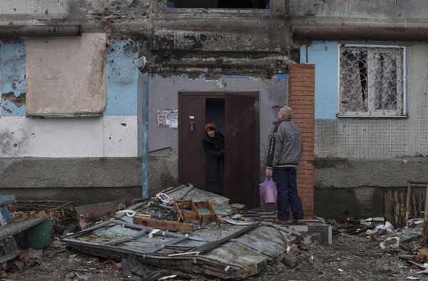 Жители Донецка у подъезда дома, поврежденного в результате обстрелов Жители Донецка у подъезда дома, поврежденного в результате обстрелов