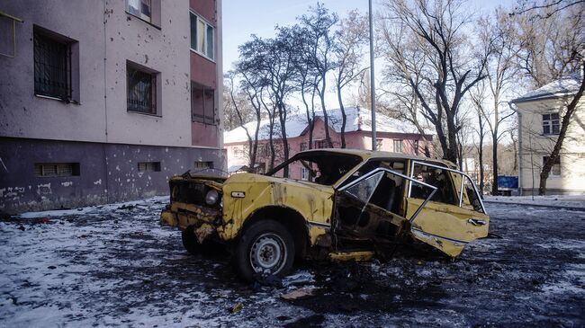 Автомобиль, поврежденный в результате обстрелов, в Киевском районе Донецка. Архивное фото