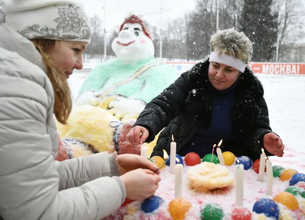 Участники зажигают свечи на снежном торте во время Арт-битвы Снеговиков в Московском Дворце пионеров на Воробьевых горах