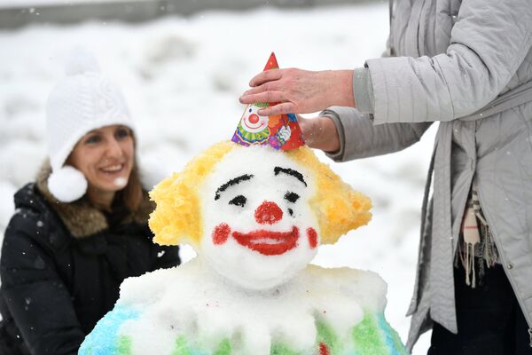 Участники украшают фигуру из снега во время Арт-битвы Снеговиков в Московском Дворце пионеров на Воробьевых горах