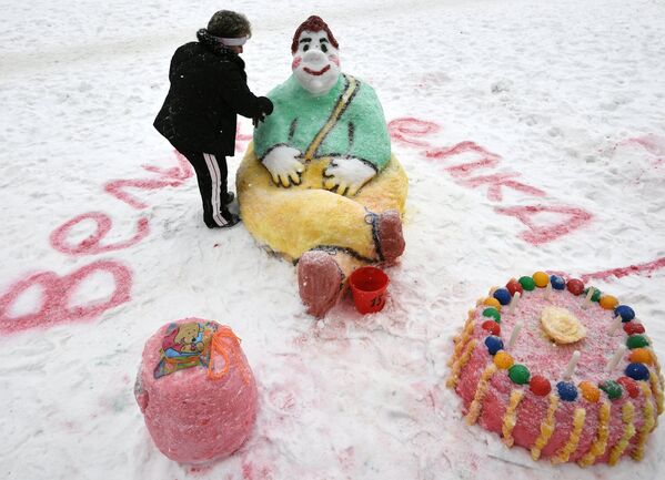 Участница украшает снежную фигуру во время Арт-битвы Снеговиков в Московском Дворце пионеров на Воробьевых горах