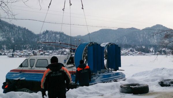 Сотрудники МЧС спускают на озеро Телецкое судно на воздушной подушке для проведения поисковых работ в связи с падением вертолета Робинсон