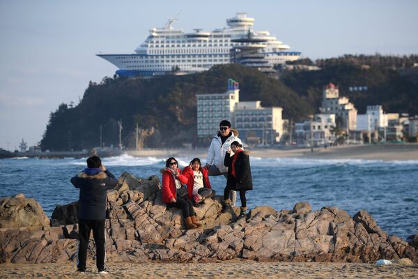 Туристы фотографируются на фоне тематического отеля Sun Cruise Resort в городе Чондончжин в Республике Корея