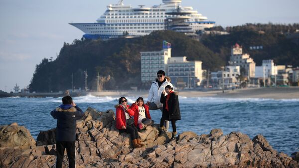 Туристы фотографируются на фоне тематического отеля Sun Cruise Resort в городе Чондончжин в Республике Корея