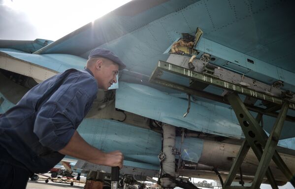 Техник во время обслуживания многофункционального истребителя-бомбардировщика Су-34 на авиабазе Хмеймим в сирийской провинции Латакия