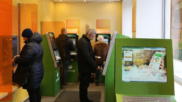 Посетители в зале банкоматов в отделении Сбербанка РФ. Архивное фото