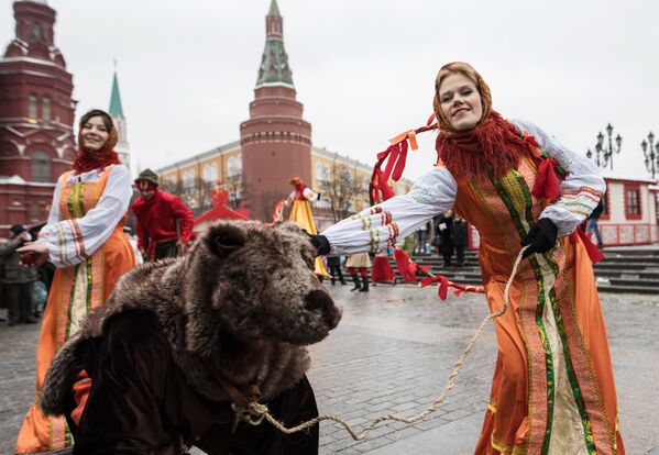 Участницы анимационной программы с актером в костюме медведя во время открытия фестиваля Московская масленица на Манежной площади