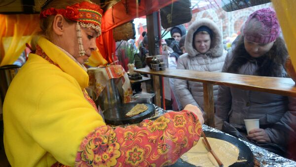 Продавщица блинов на фестивале Московская масленица на Манежной площади в Москве