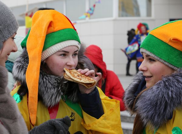 Участники кушают блины во время массового масленичного гуляния Блинно-сырное веселье в Белгороде