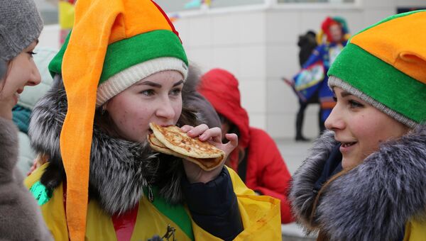 Участники кушают блины во время массового масленичного гуляния Блинно-сырное веселье в Белгороде