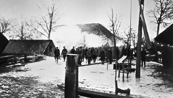 Солдаты входят на сожженный крестьянский двор, принадлежавший участнику восстания в Прибалтике в 1917 г.